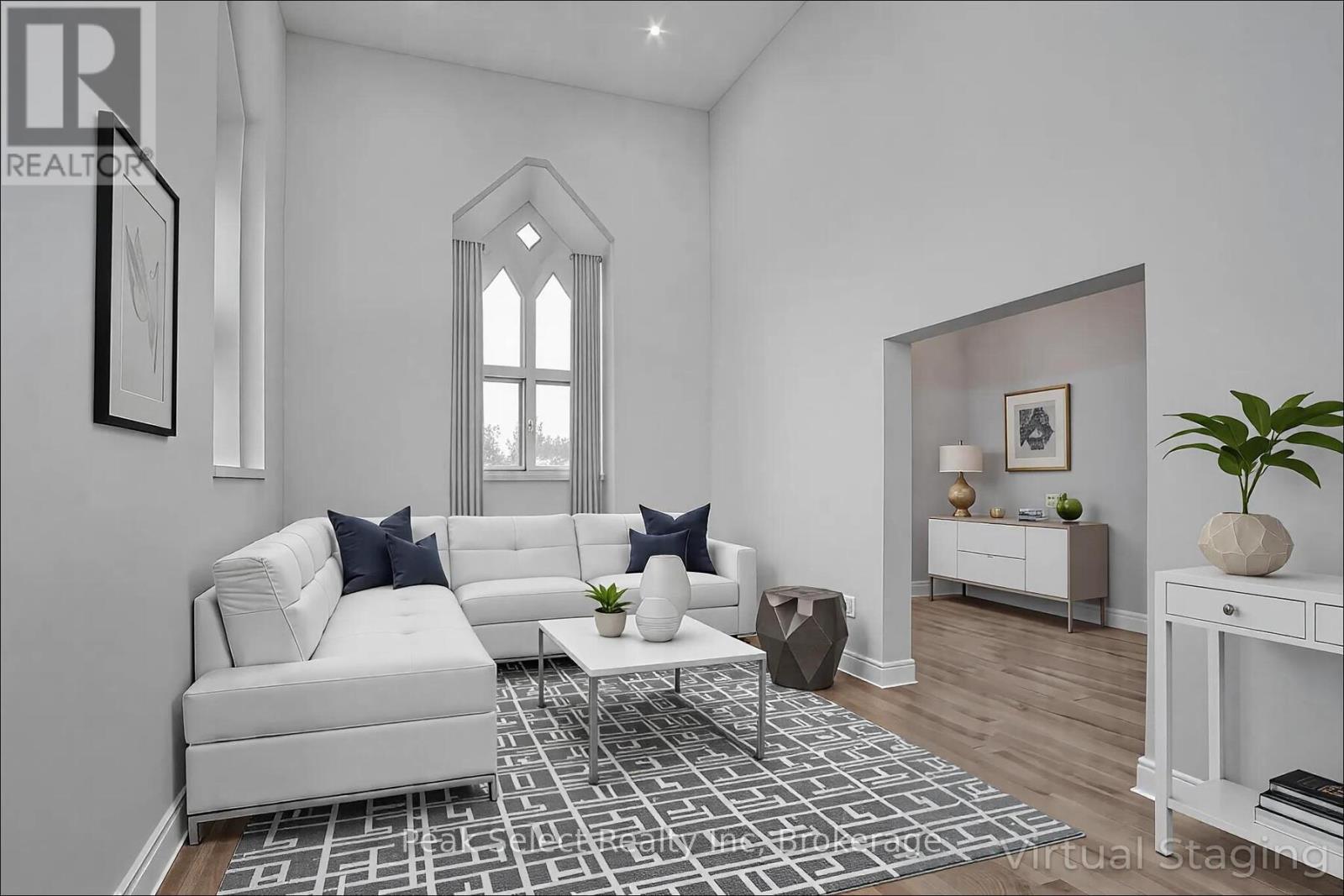 A living room with a white sofa and a patterned rug.
