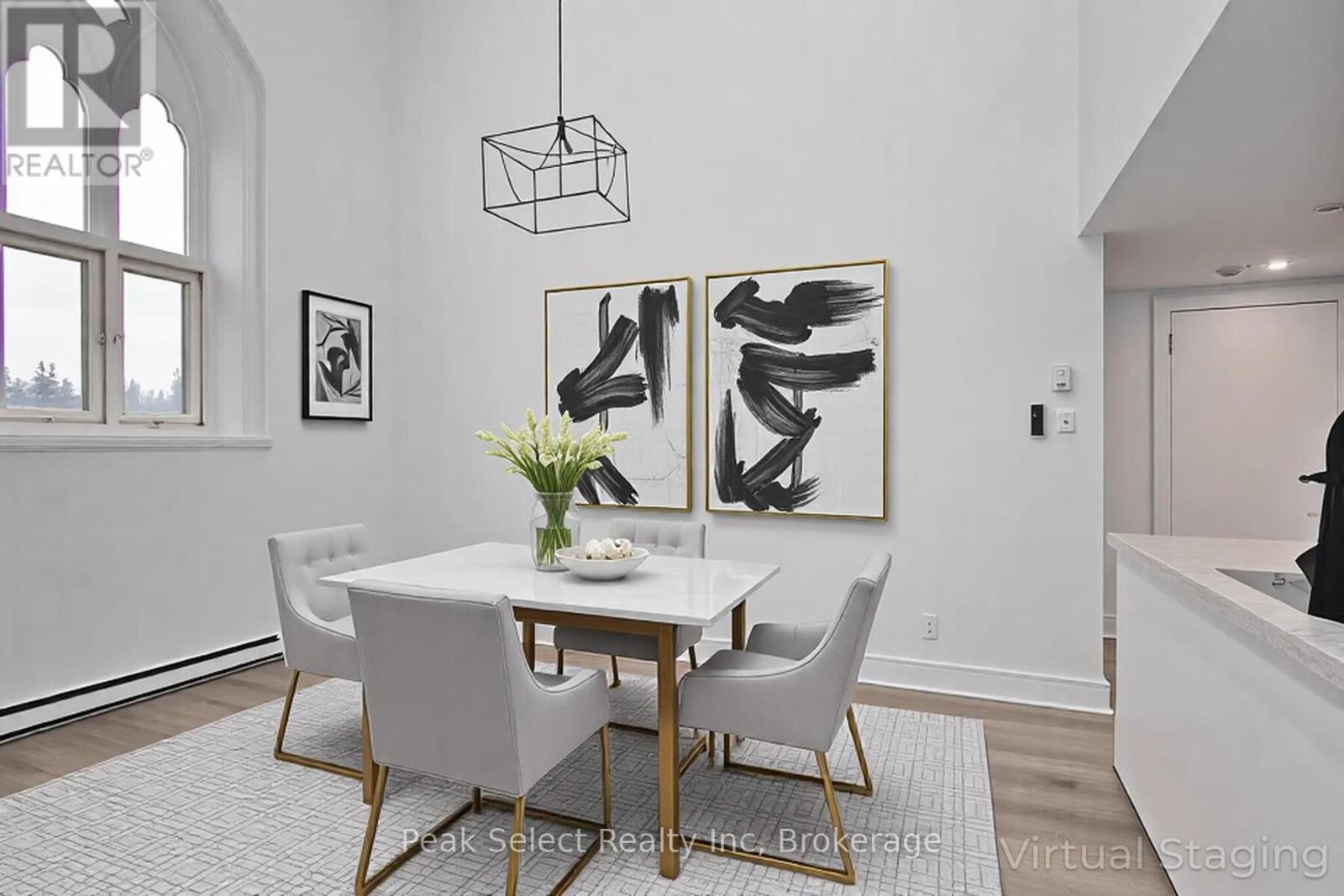 A dining room with a white table and chairs.