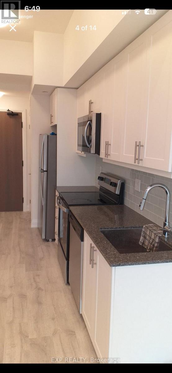 A kitchen with white cabinets and a black countertop.