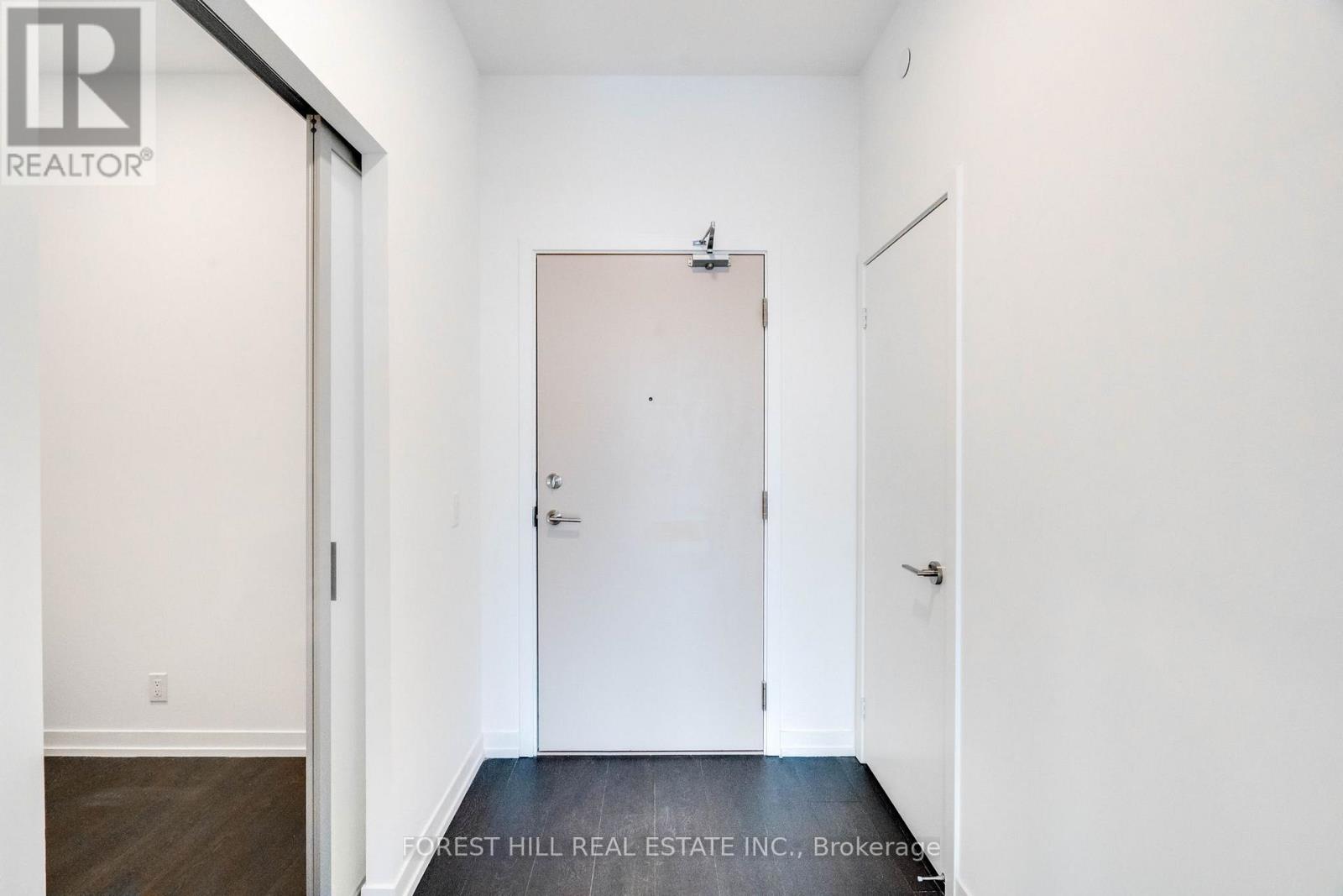 A white door in a room with a Forest Hill Real Estate Inc. logo.
