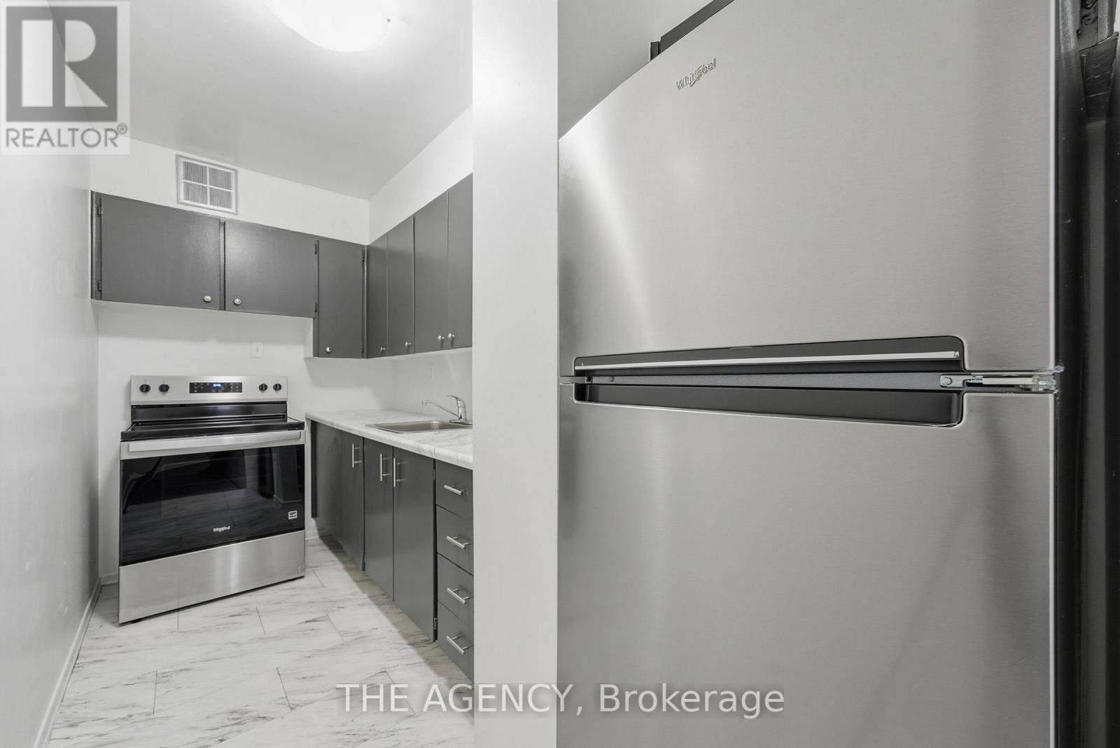 A kitchen with a stainless steel refrigerator and oven.