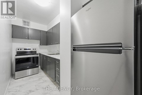 A kitchen with a stainless steel refrigerator and oven.