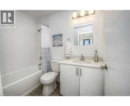 A white bathroom with a toilet, sink, and shower.