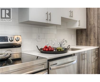 A modern kitchen with stainless steel appliances and a marble countertop.