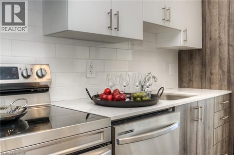 A modern kitchen with stainless steel appliances and a marble countertop.