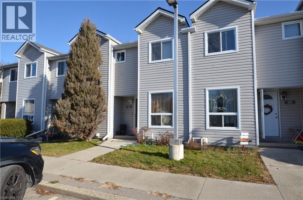 A realtor photo of a grey house with a white door and windows.