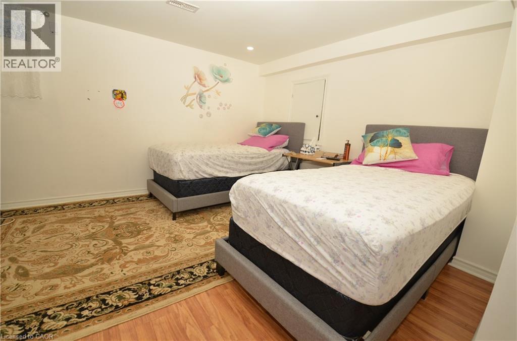 A bedroom with two beds and a rug on the floor.