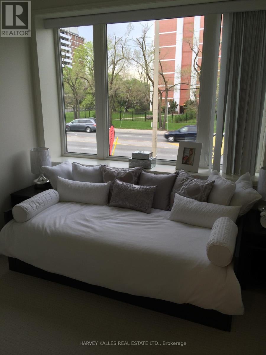 A bedroom with a large bed and a window overlooking a street.