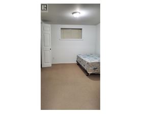 A bedroom with a bed, a door, and a window.