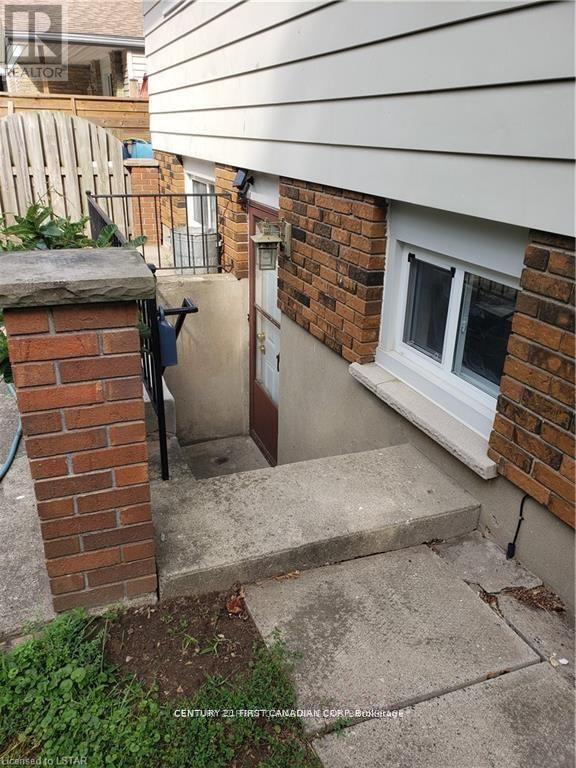 A brick pillar with a metal railing next to a white window.