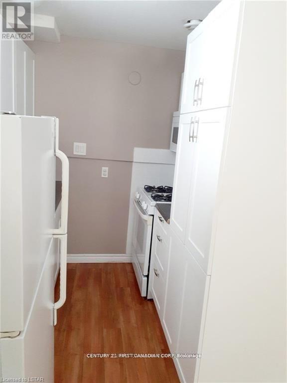 A kitchen with white appliances and cabinets.