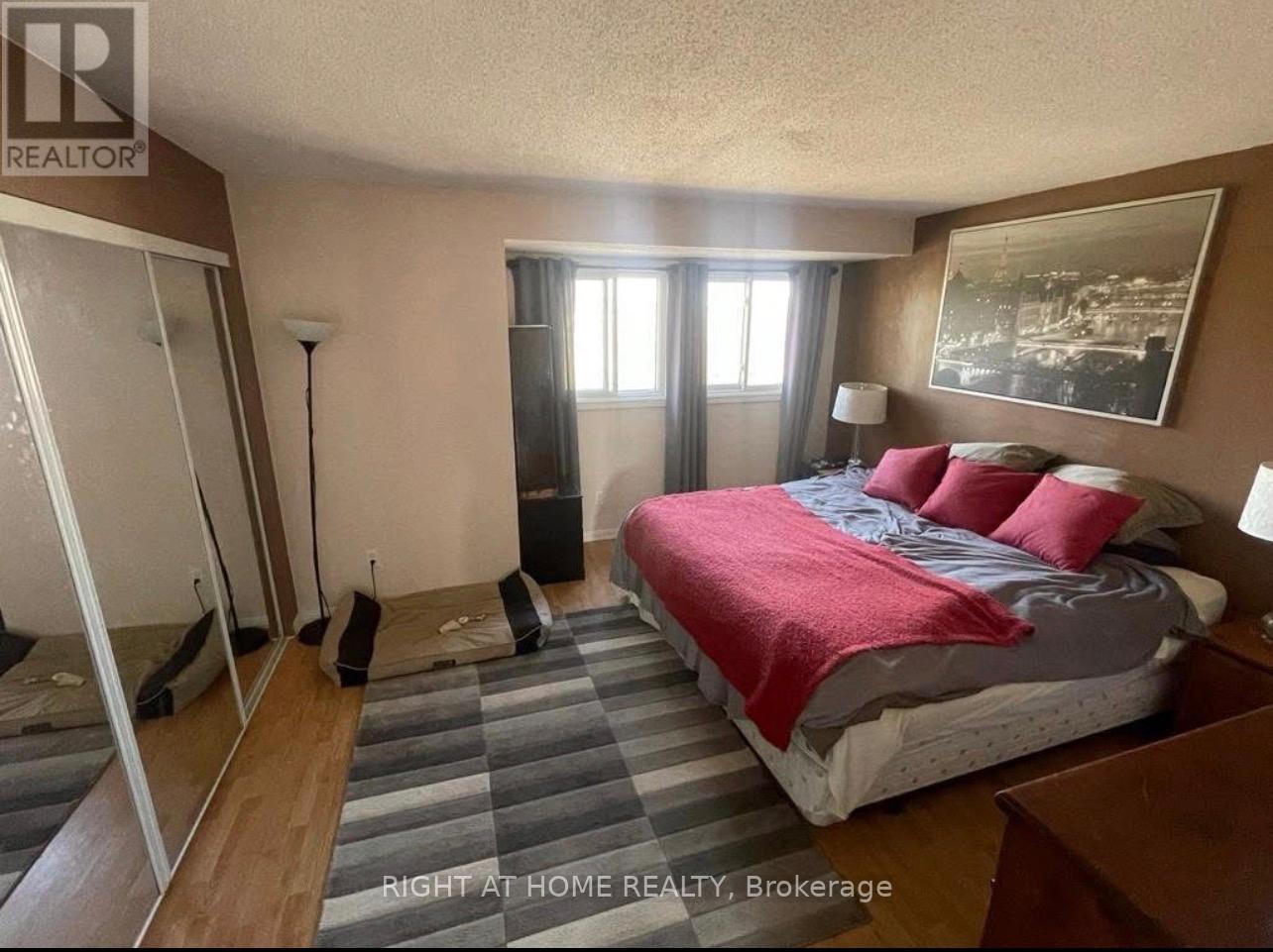 A bedroom with a bed, nightstand, and a mirror.