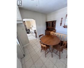 A dining room with a wooden table and chairs.