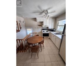 A kitchen with a table and chairs.