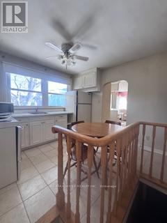 A kitchen with a refrigerator, dishwasher, and a ceiling fan.
