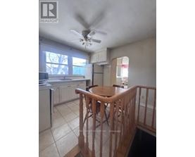 A kitchen with a refrigerator, dishwasher, and a ceiling fan.
