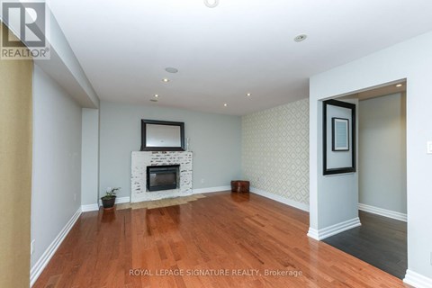 A living room with a fireplace and a painting on the wall.
