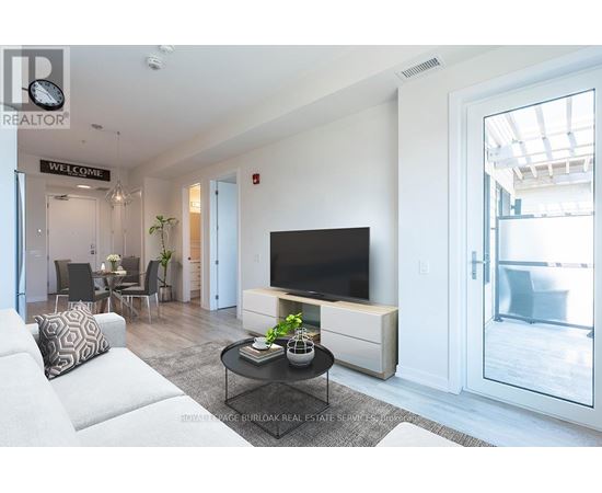 A living room with a white couch and a black television.