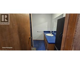 A bathroom with a blue counter top and a wooden door.