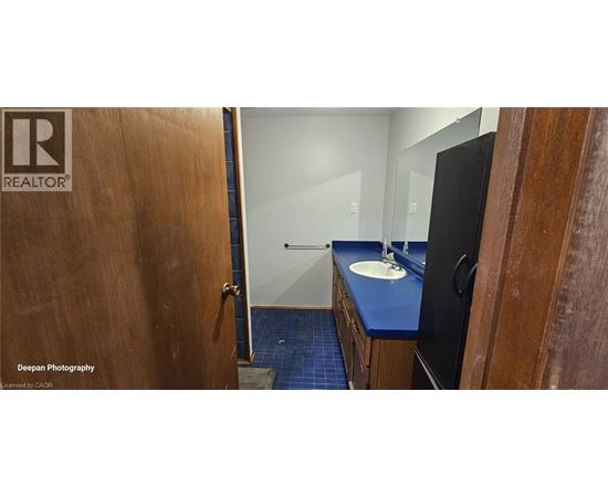 A bathroom with a blue counter top and a wooden door.