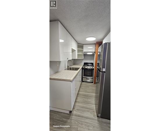 A kitchen with white cabinets and a wooden countertop.