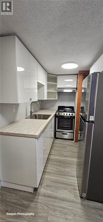A kitchen with white cabinets and a wooden countertop.