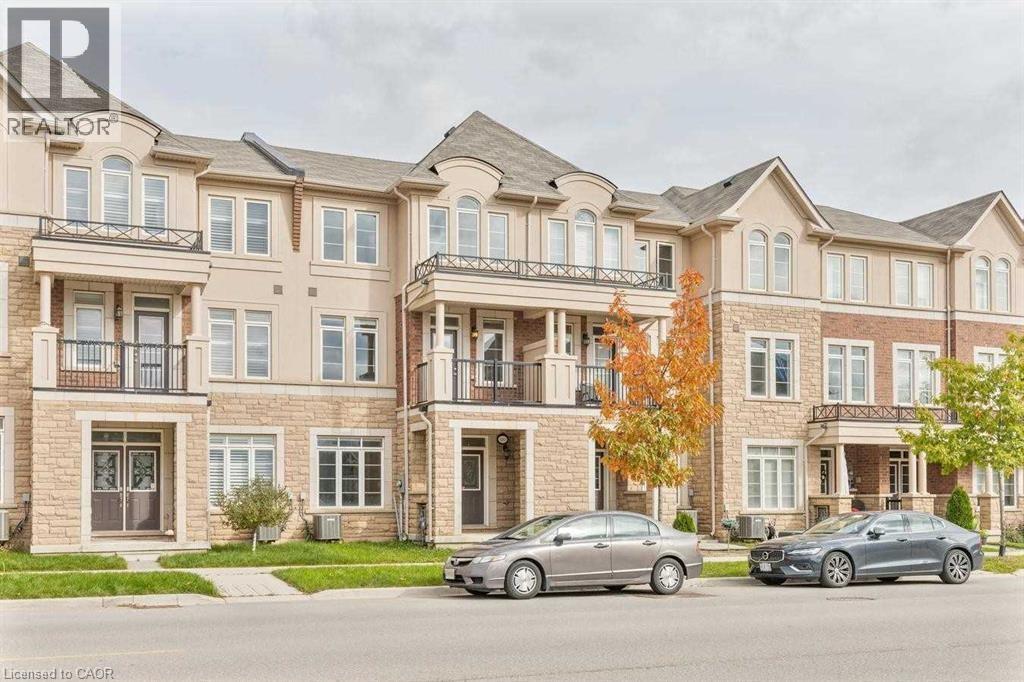 A large, multi-story residential building with two cars parked in front.