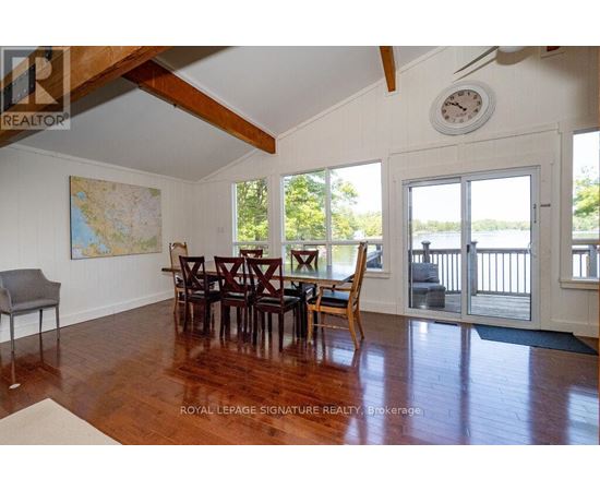 A dining room with a wooden table and chairs.