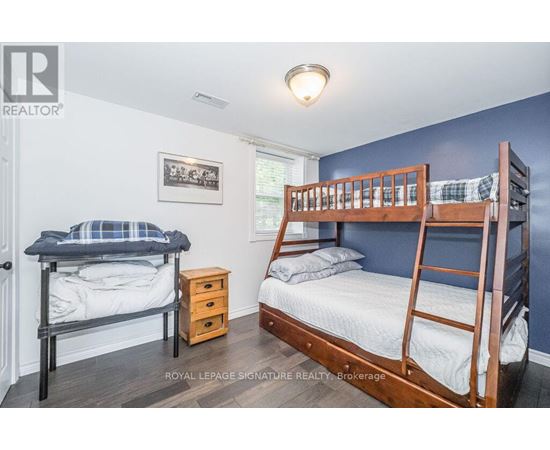 A bedroom with two beds and a dresser.