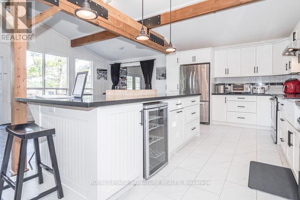 A kitchen with white cabinets and a black stool.