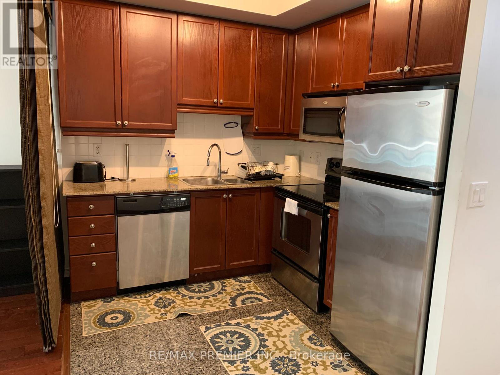A kitchen with wooden cabinets and stainless steel appliances.