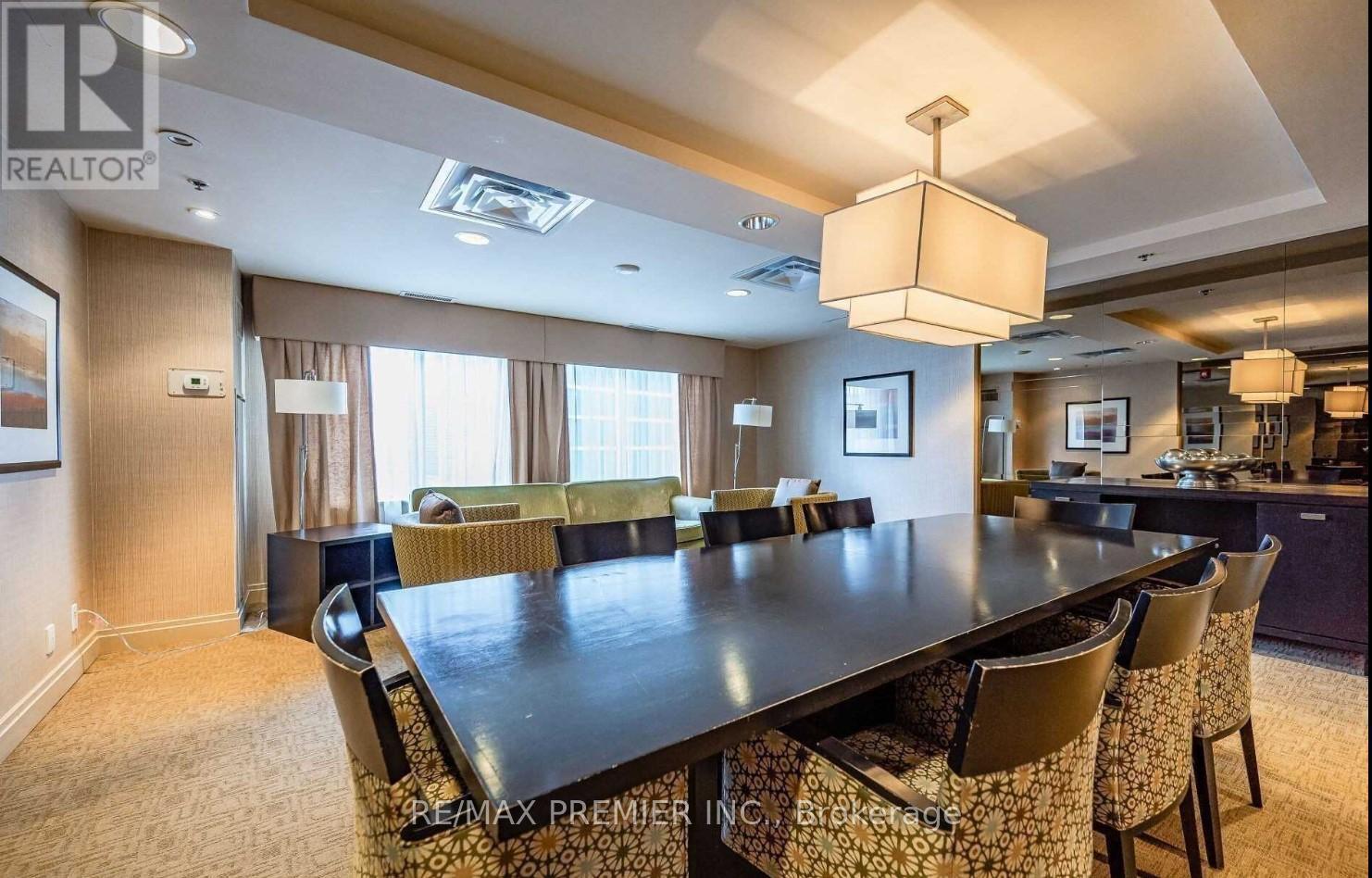 A dining room with a large table and chairs.