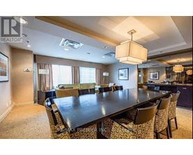 A dining room with a large table and chairs.