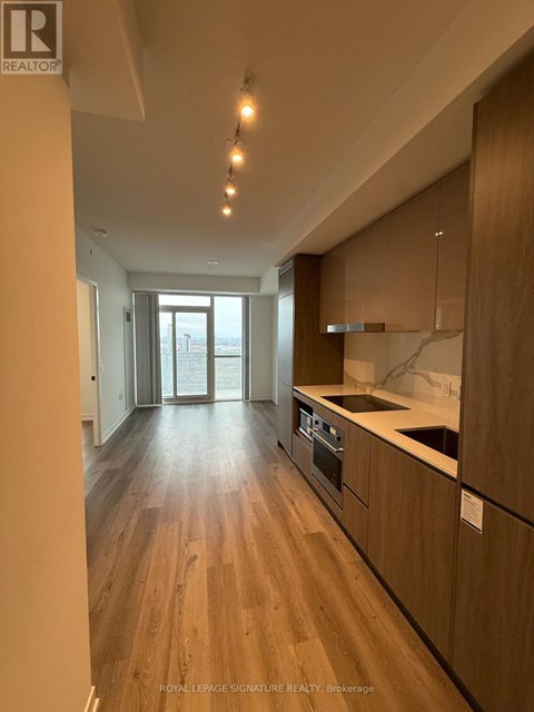 A modern kitchen with wooden floors and cabinets.
