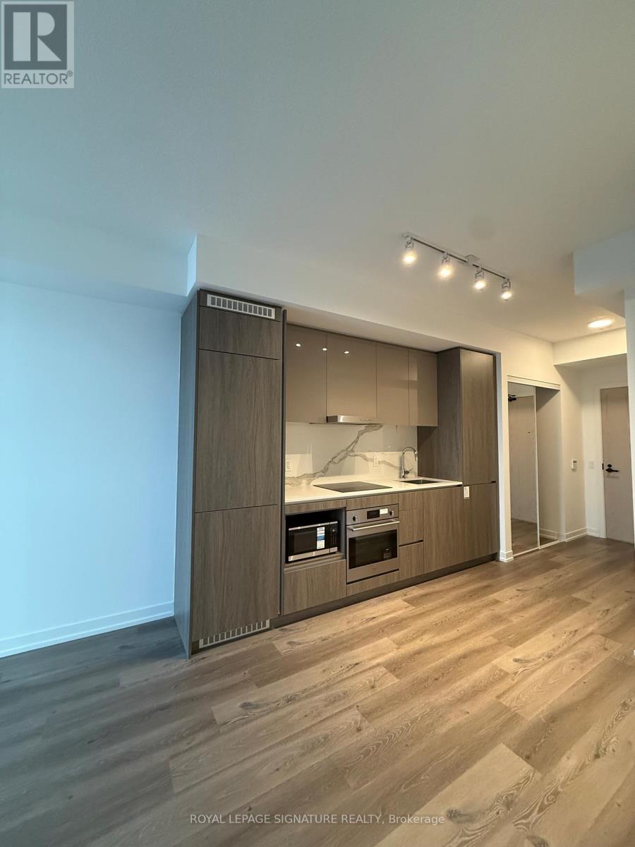 A modern kitchen with wooden floors and a large island.