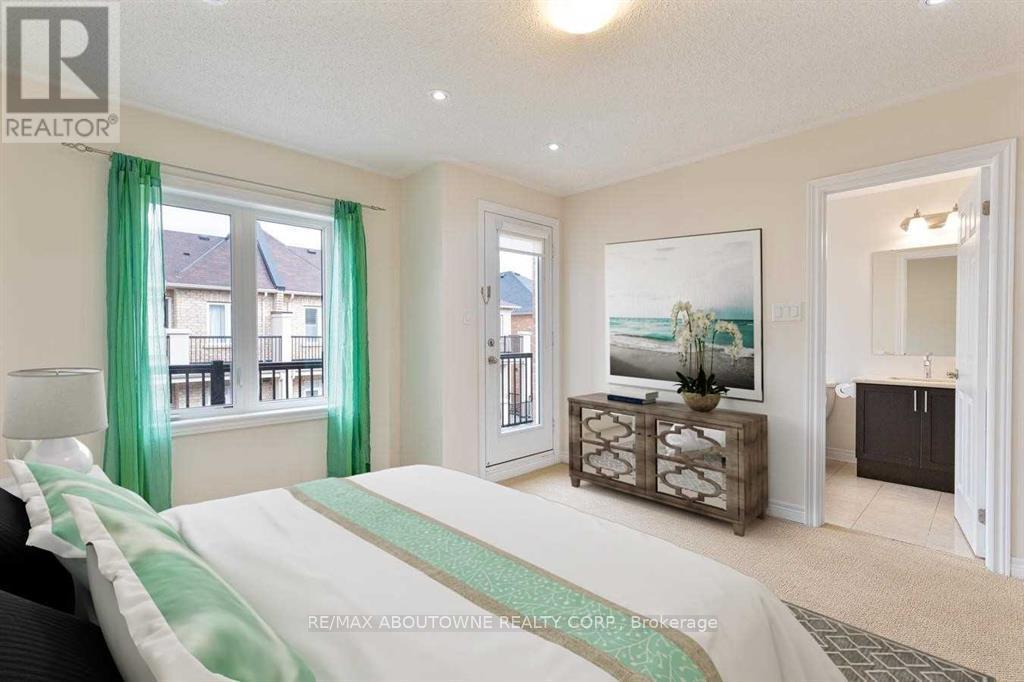 A bedroom with a large bed and a balcony with a view of buildings outside.