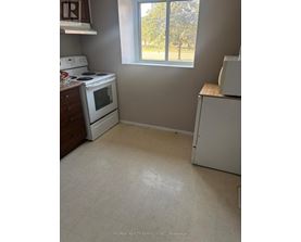 A small kitchen with a white stove and a white refrigerator.