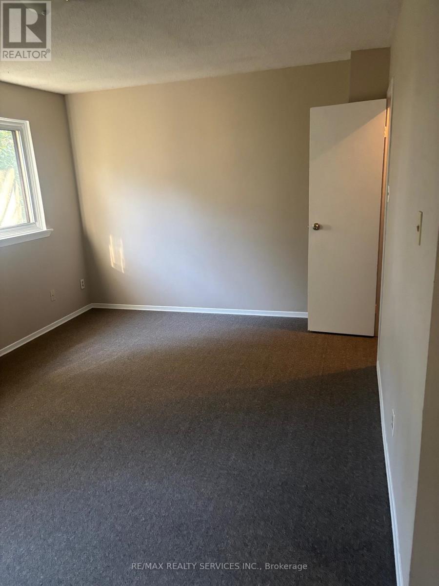 A room with a carpeted floor and a white door.