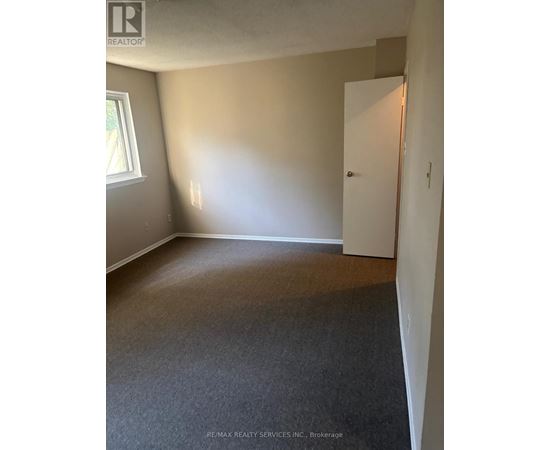 A room with a carpeted floor and a white door.