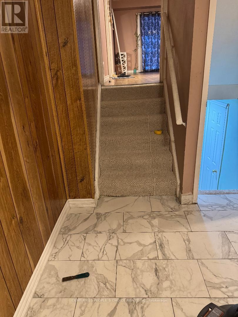 A hallway with a marble floor and wooden walls.