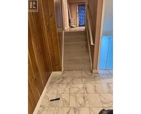 A hallway with a marble floor and wooden walls.