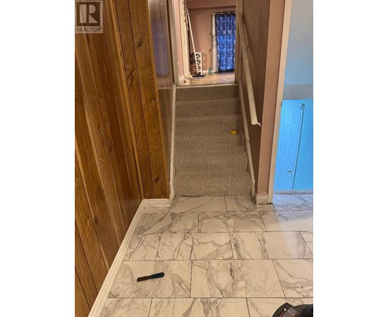 A hallway with a marble floor and wooden walls.