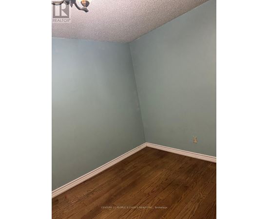 A room with wooden flooring and a light blue wall.