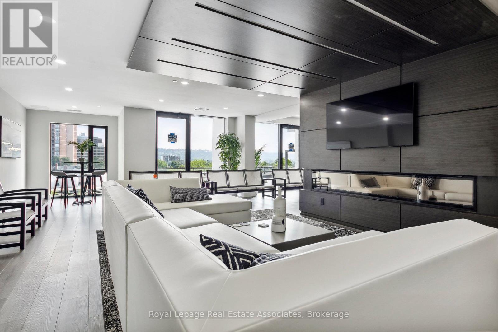 A modern living room with a white sofa and a television mounted on the wall.