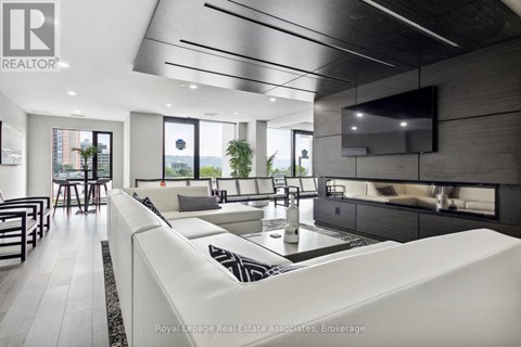 A modern living room with a white sofa and a television mounted on the wall.