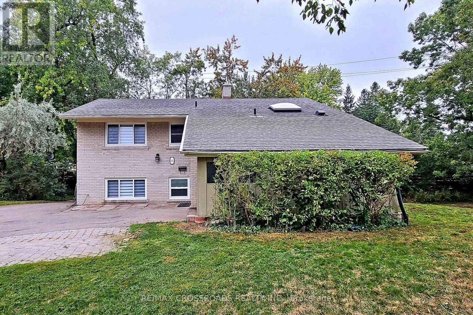 A house with a grey roof and a grey wall with a small window.