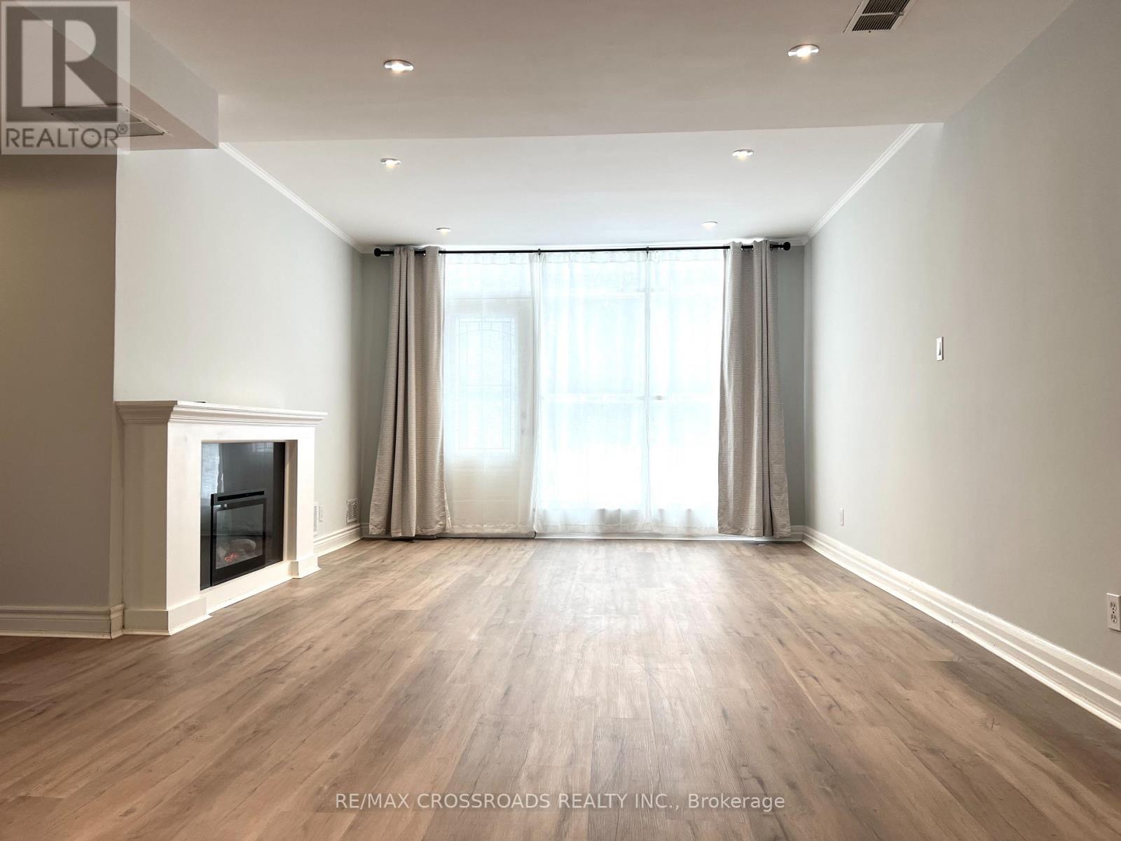 A spacious room with a fireplace and large windows.
