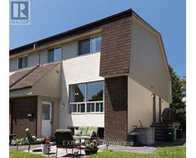 A house with a brown roof and a white wall is for sale.