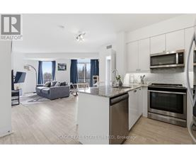 A modern kitchen with stainless steel appliances and a dining area with a couch and chairs.