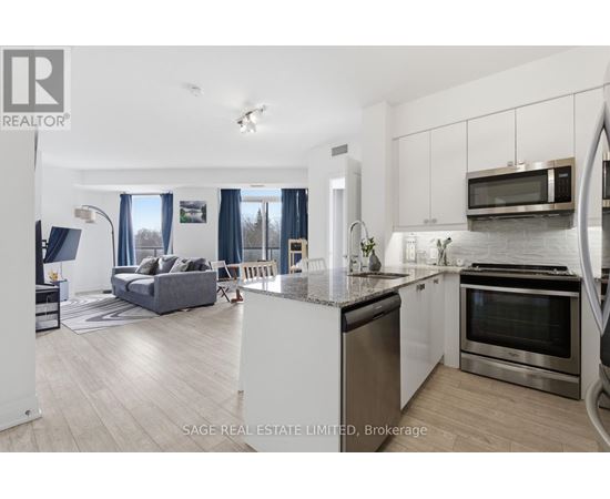 A modern kitchen with stainless steel appliances and a dining area with a couch and chairs.